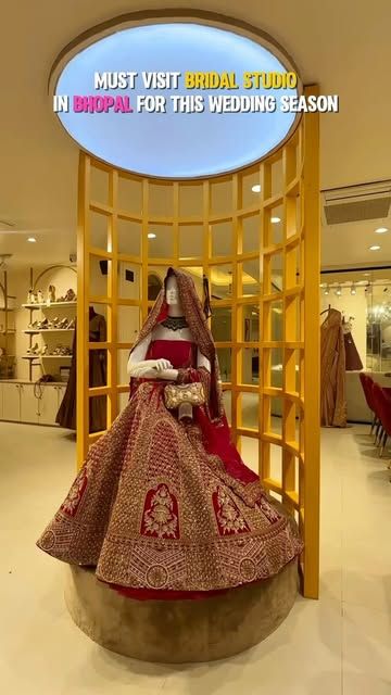 Red bridal lehenga displayed on a round plinth in the studio