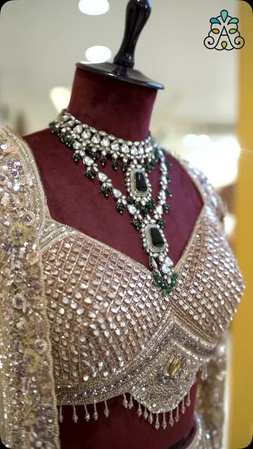 Green stone necklace on an embellished choli on a mannequin