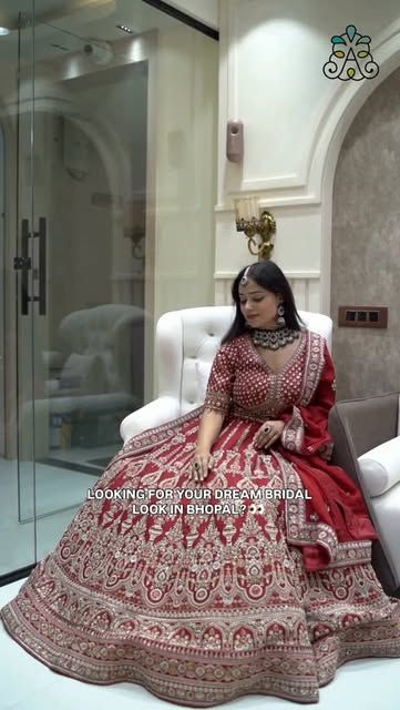 Bride seated in a red lehenga inside the studio